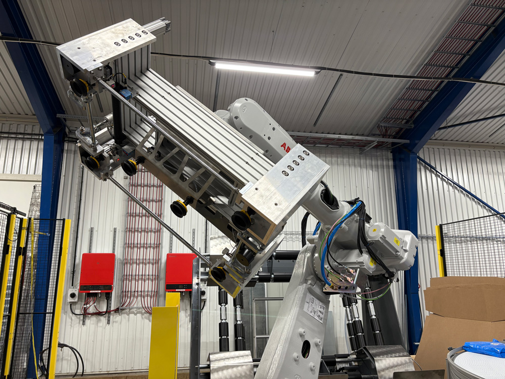 Robotic palletizing cell with industrial robot arm handling products at end of production line