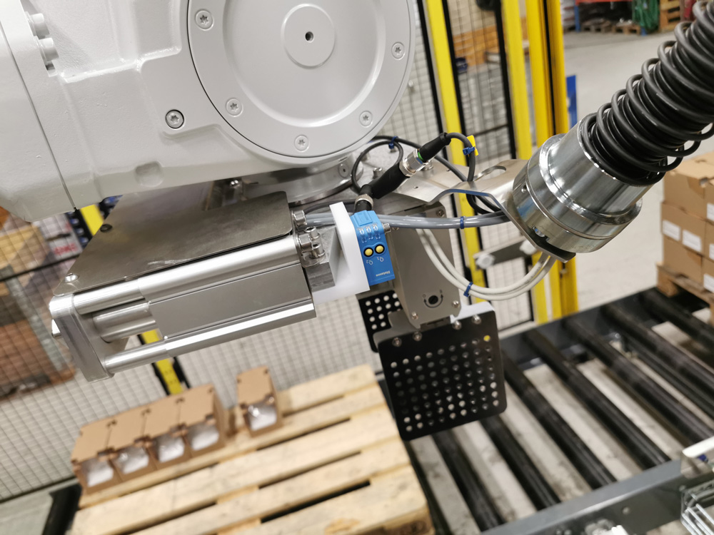 Robotic arm on palletizing machine working in factory
